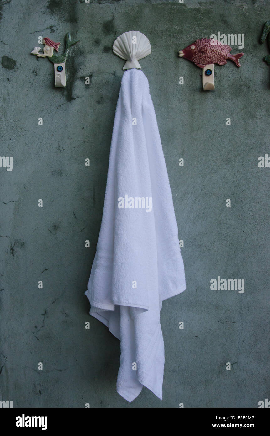 Ein weißes Handtuch hängt an einem Shell-Haken in eine Dusche im freien Bereich in der Karibik Stockfoto