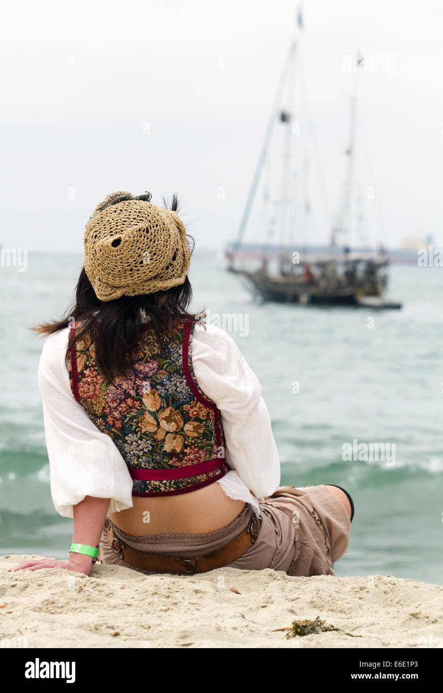 Junge weibliche Piraten am Strand sitzen Stockfoto