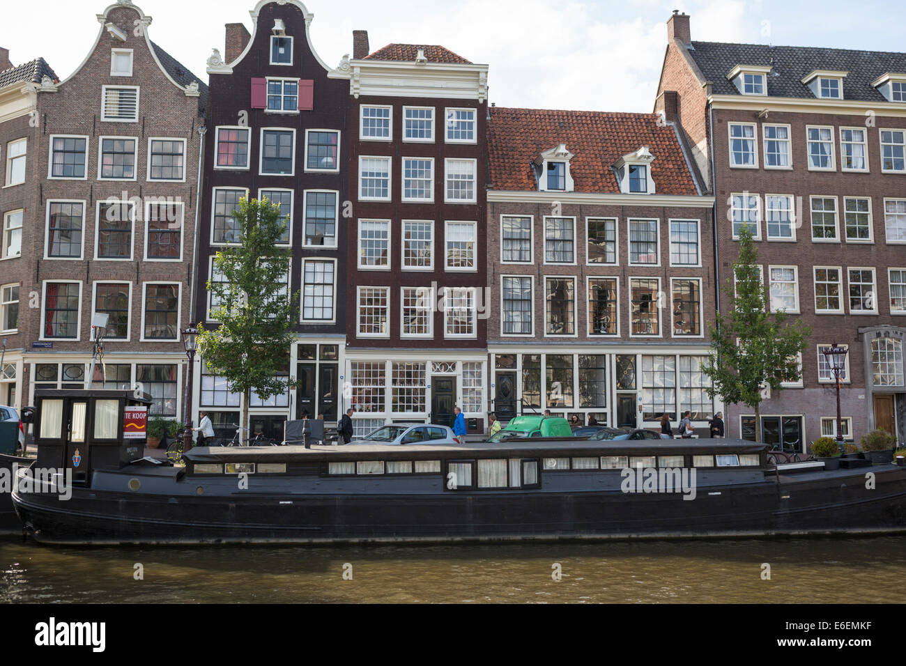 Blick auf einen der Kanäle mit einem Hausboot und historische Häuser im berühmten Stadtteil 'Jordaan' in Amsterdam. Stockfoto