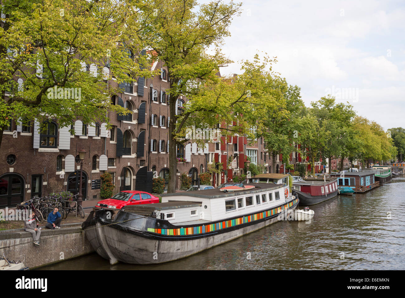 Menschen entspannen an der Seite eines der Kanäle (Prinsengracht) in Amsterdam in den Niederlanden Stockfoto