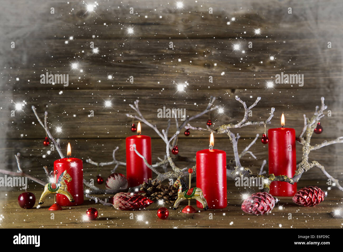 Xmas Dekoration auf hölzernen rustikalen Hintergrund: vier rote brennende  Advent Kerzen. Verschneite Land Stil Rahmen Stockfotografie - Alamy