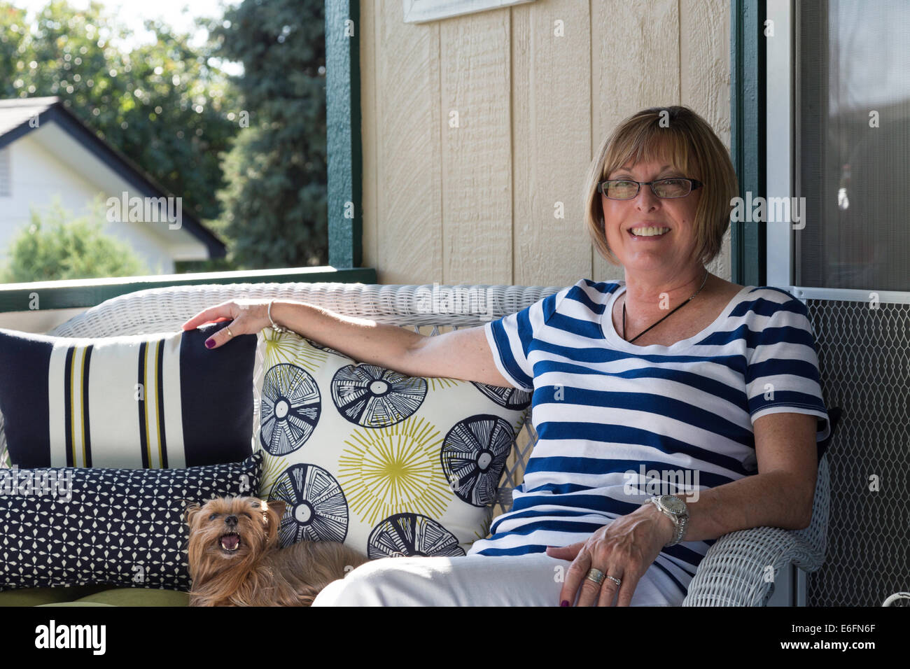 Frau mit Hund Haustier Yorkie auf ihrem Hinterhof Deck, USA Stockfoto