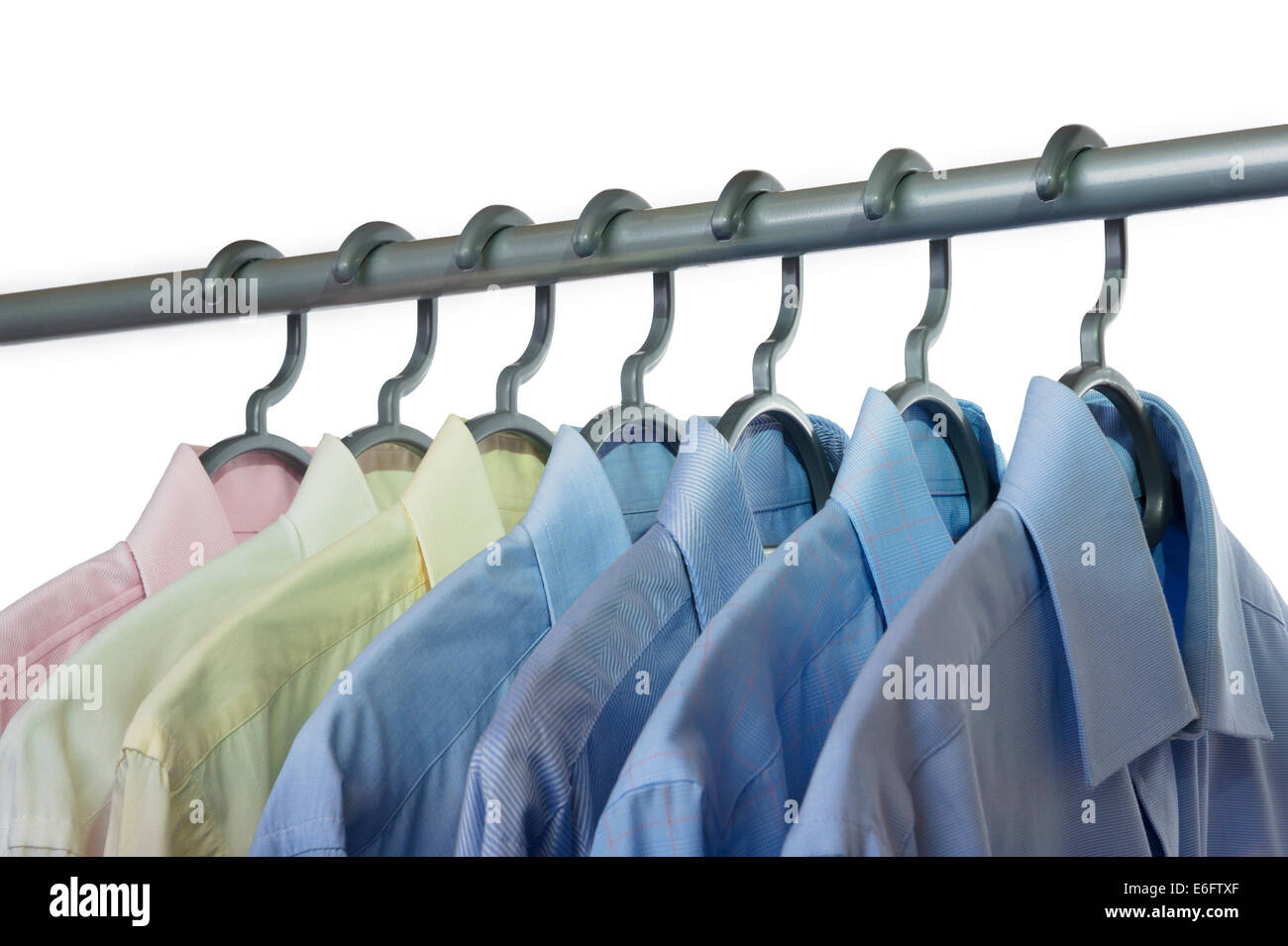 Sieben Menshemden an eine Kleiderstange hängen. Stockfoto
