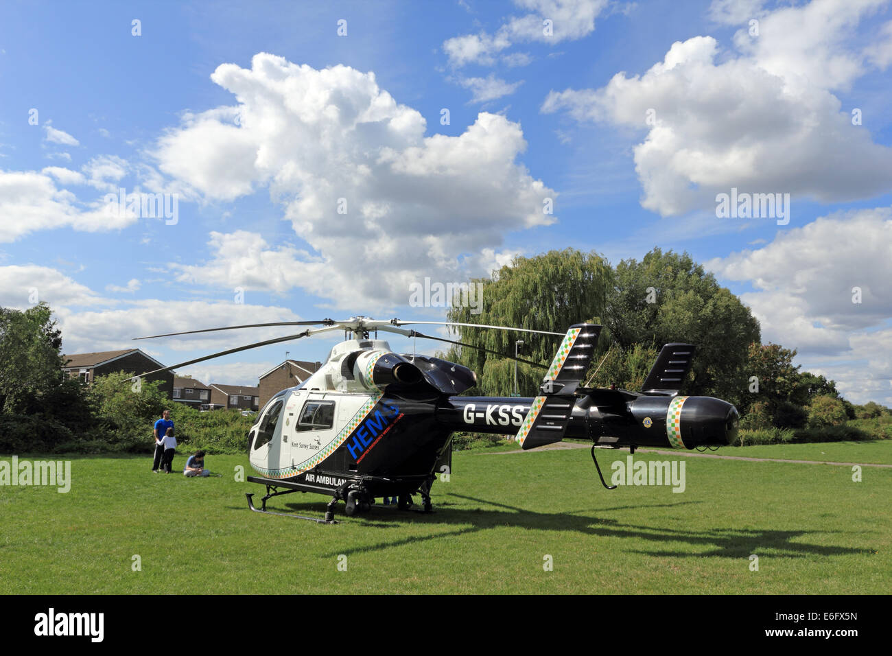 Westen Ewell, Epsom, Surrey, UK. 22. August 2014. Bewohner von West Ewell hatte eine Überraschung heute Nachmittag als KSSA (Kent Surrey Sussex Air Ambulance) landete auf einer Fläche von den Hogsmill Freiraum zwischen Riverview Schule und Waters Estate. Er landete um 13.30 Uhr in Reaktion auf "Ein medizinischer Notfall" auf dem Anwesen. Einheimischen versammelt, um zu sehen, der ungewöhnliche Ort eines Hubschraubers so nah an in der Nähe wohnen, und wie es war Ferienzeit im Sommer viele neugierige Kinder waren daran interessiert, das Ereignis beizuwohnen. Bildnachweis: Julia Gavin UK/Alamy Live-Nachrichten Stockfoto