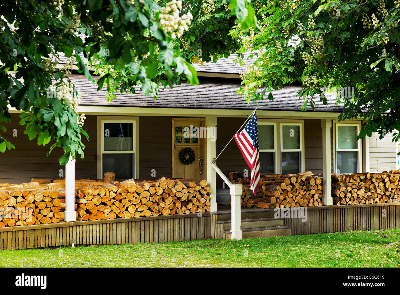 Haus in Joseph Oregon mit Brennholz gestapelt auf Veranda. Stockfoto