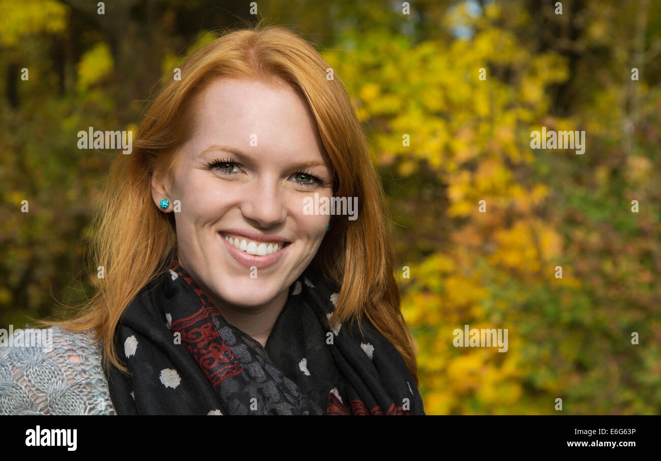 Porträt, natürliche rothaarige junge lächelnde Frau im Herbst bei einem Spaziergang. Stockfoto
