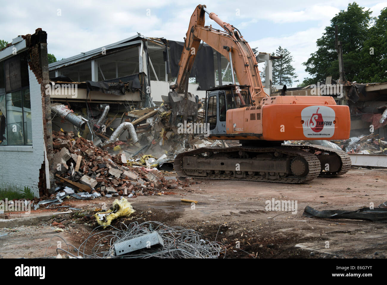 Bagger mit Greifer Abbruch Arbeit auf Bürogebäude in Norwalk, CT.  Materialien für das recycling sortiert. Stockfoto
