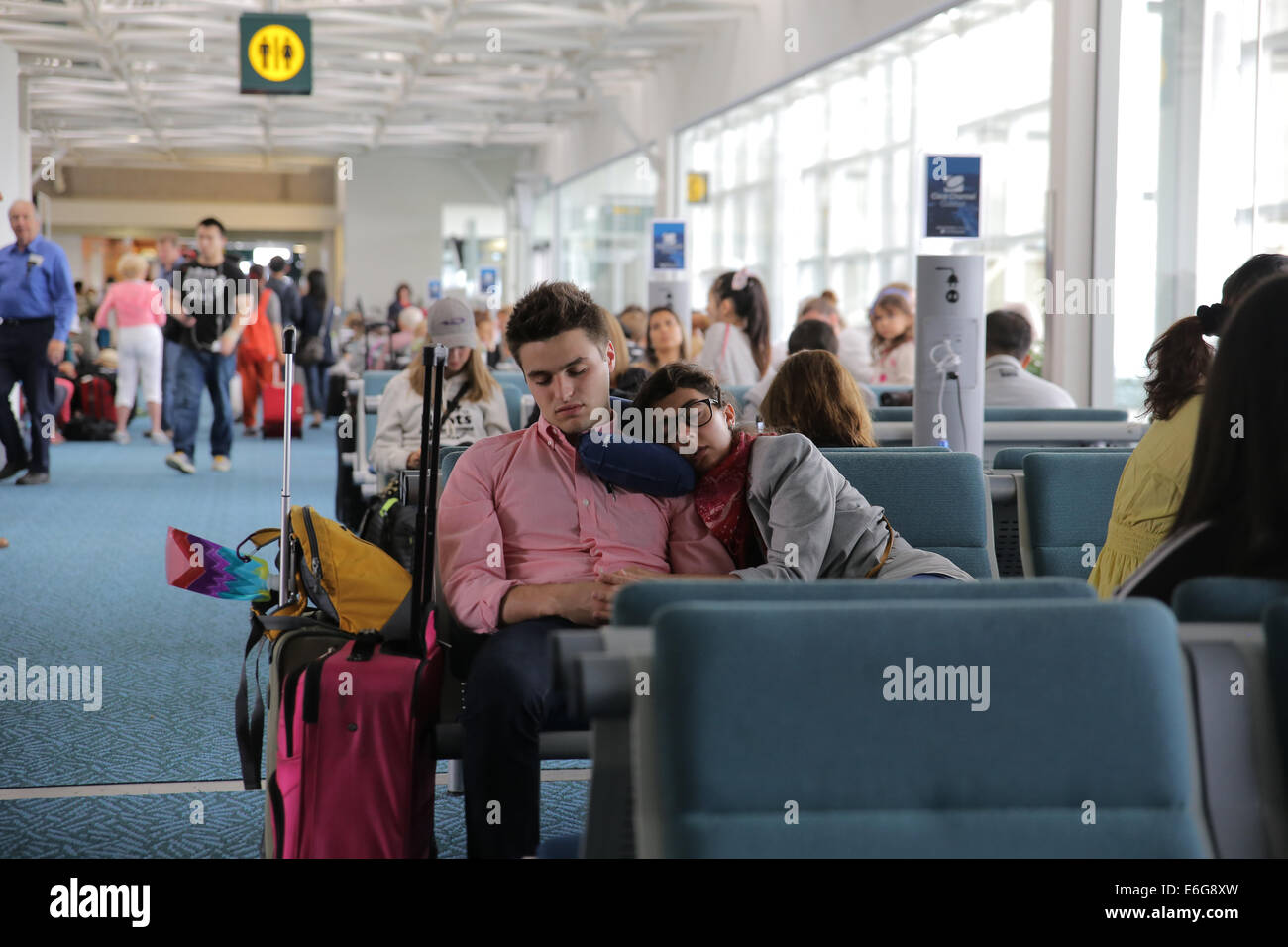 müde, erschöpft Passagier Läppen im Flughafen boarding Gate-Bereich Stockfoto