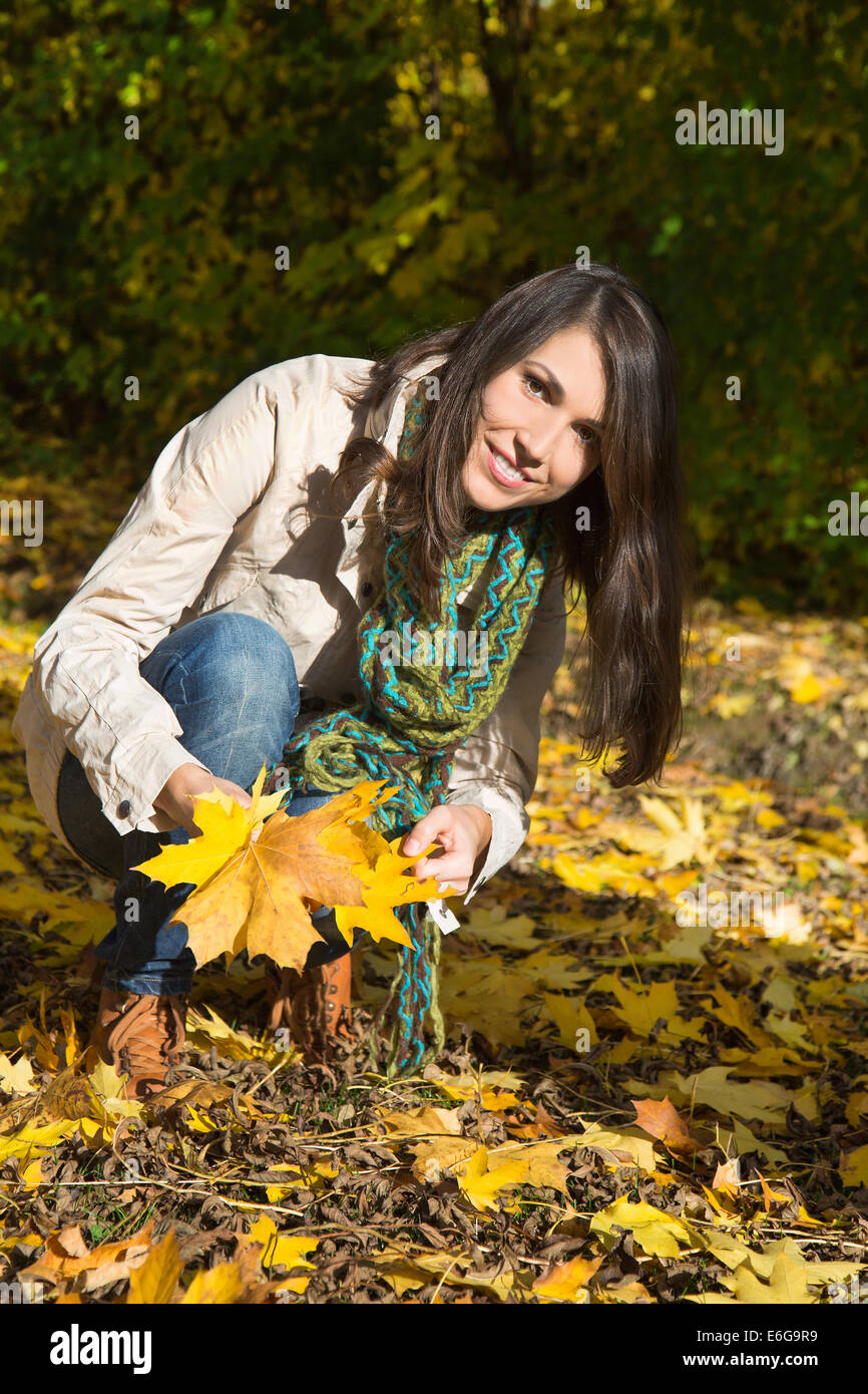 Glückliche junge attraktive Frau bei einem Spaziergang im Herbst halten lässt in ihren Händen. Stockfoto