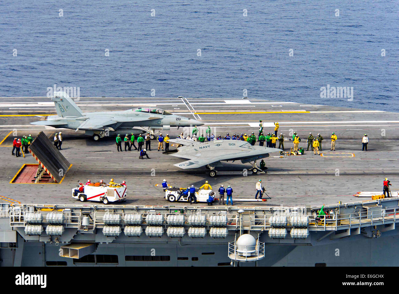 Die US Navy X-47 b, die autonomen stealth unbemannten neben einer f-15-Kampfflugzeuge auf dem Flugdeck des Flugzeugträgers USS Theodore Roosevelt während Tests demonstriert die Fähigkeit, sicher und nahtlos mit betreiben betreibt bemannte Flugzeuge 17. August 2014 in den Atlantischen Ozean. Stockfoto