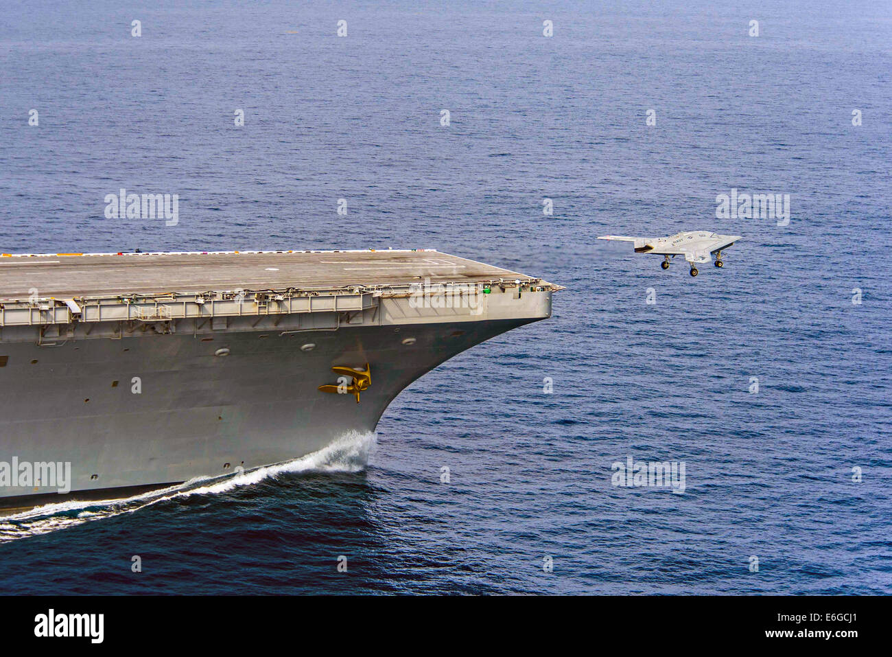 Die US Navy X-47 b, die autonomen stealth unbemannten aus dem Flugdeck des Flugzeugträgers USS Theodore Roosevelt während Tests demonstriert die Fähigkeit zieht, sicher und nahtlos mit bemannten Luftfahrzeugen 17. August 2014 in den Atlantischen Ozean zu betreiben. Stockfoto