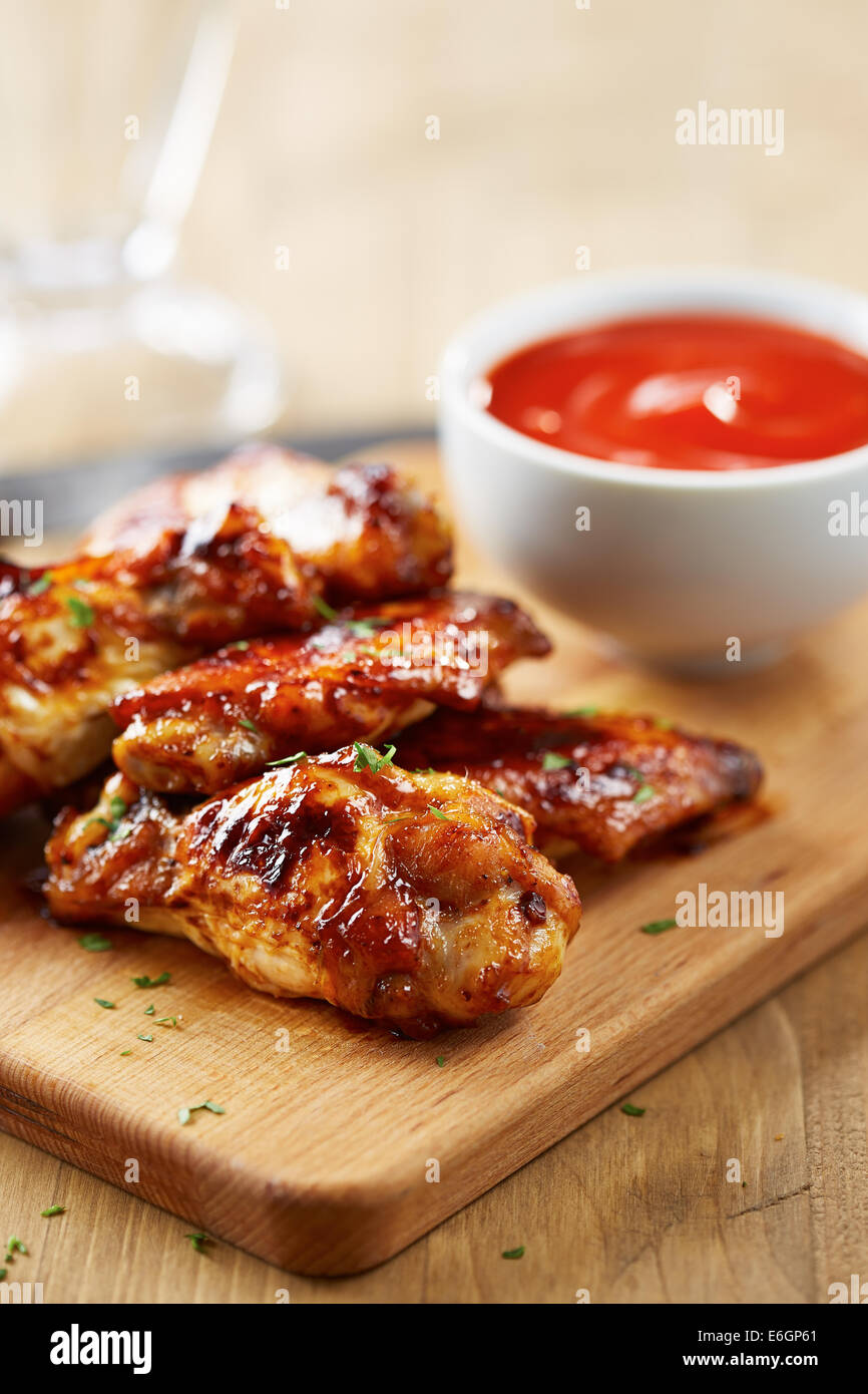 Hähnchenflügel mit Sriracha Sauce auf Holztisch Stockfoto
