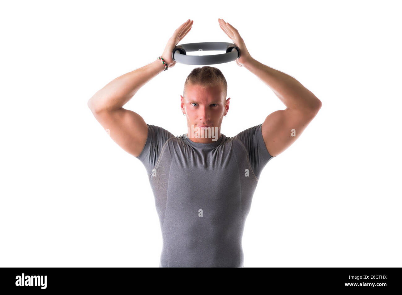 Jungen muskulöser Mann Training mit Pilates Ring über seinem Kopf, isoliert auf weiss Stockfoto