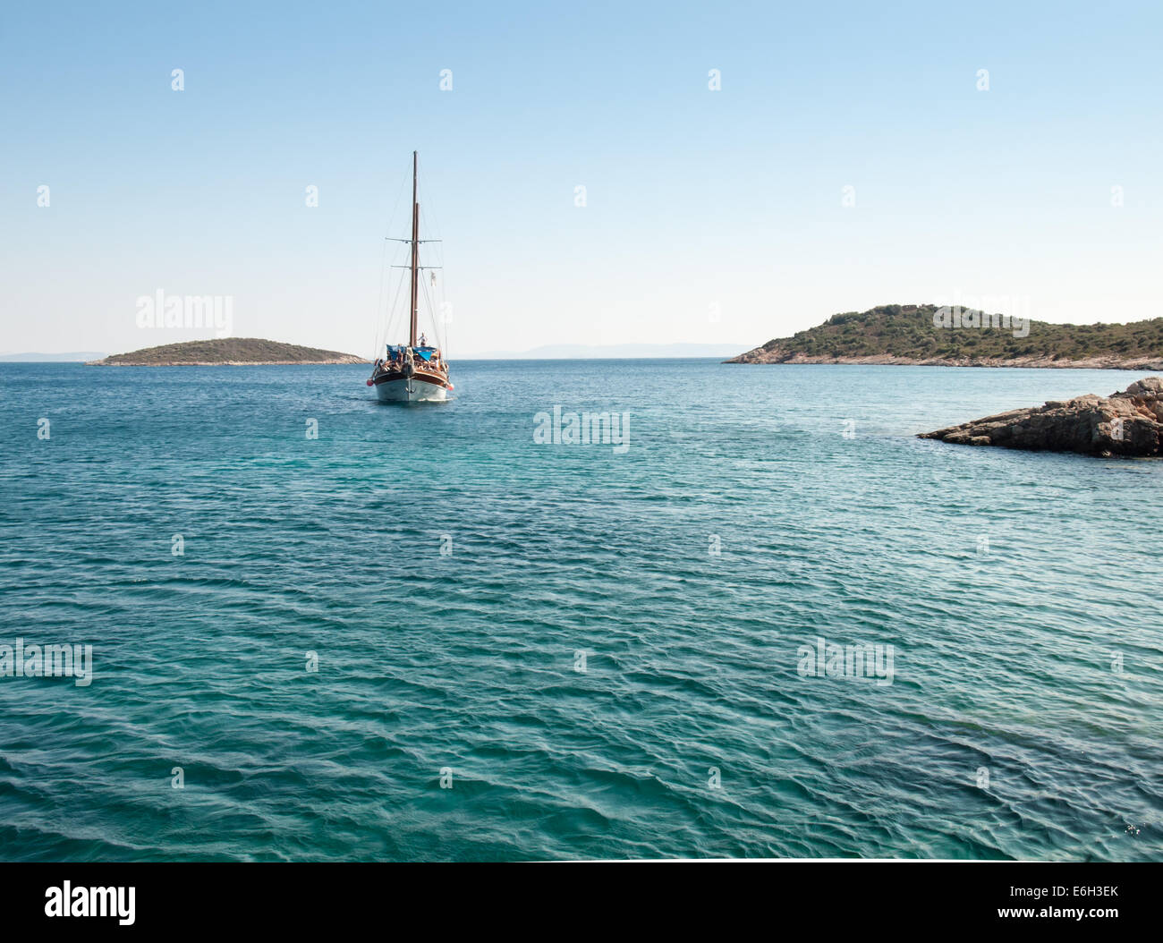 Charterboot tragen Tagesausflügler vorbei zwischen den Inseln auf das grüne Wasser an der türkischen Ägäisküste. Stockfoto