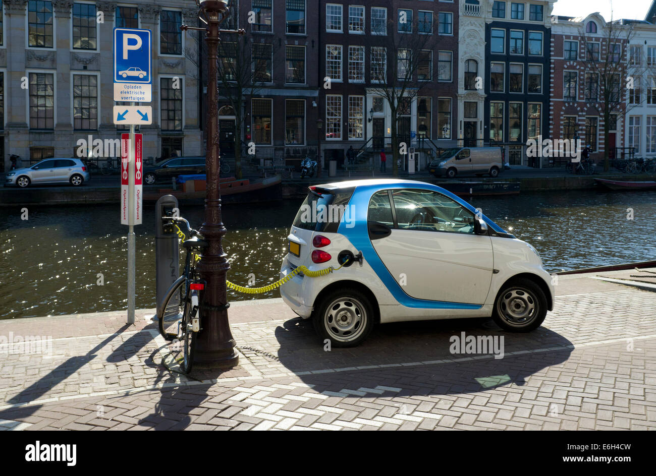 Elektro-Auto neben einem Amsterdamer Kanal eingesteckt Stockfoto