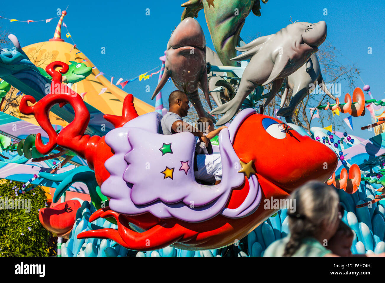 Schwarzer Mann mit weißen Kind reiten ein Fisch zwei Fische roter Fisch blau Fisch Attraktion Seuss Landing in Islands of Adventure Stockfoto