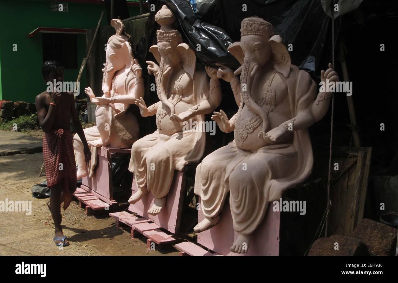 Bhubaneswar, indische Sate Orissa. 23. August 2014. Ein Junge geht vorbei an Tonfiguren von Ganesha, ein Hindu-Gott der Weisheit und des Glücks in Bhubaneswar, Hauptstadt des östlichen indischen Sate Orissa, 23. August 2014. © Stringer/Xinhua/Alamy Live-Nachrichten Stockfoto