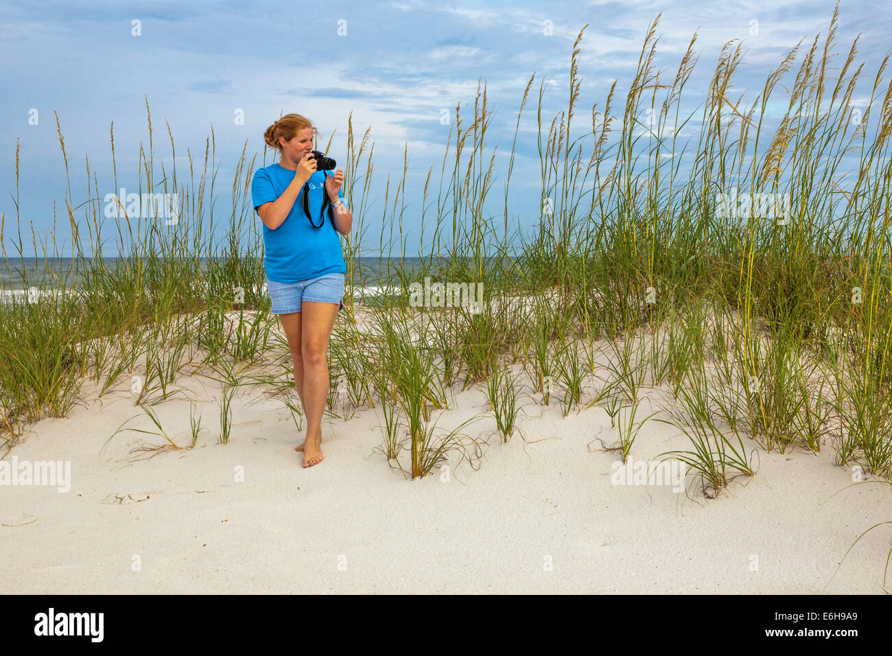 Junge weibliche Fotografin, die Erkundung der Sehafer und Sanddünen in Pensacola Beach, Florida Stockfoto