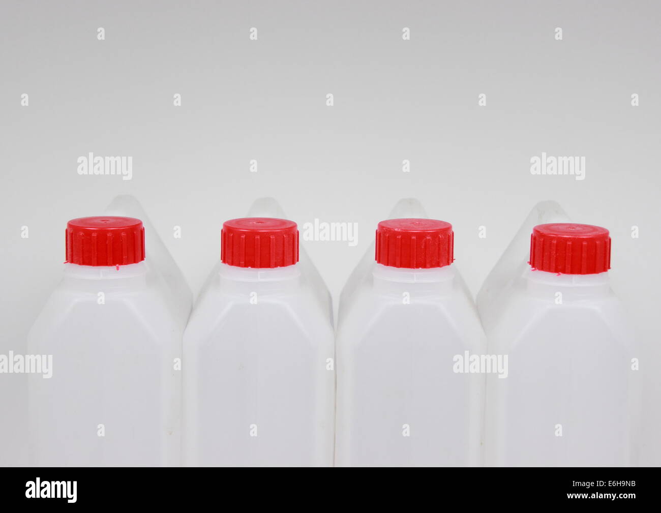 Vier leeren Kanister aus weißem Kunststoff mit rotem Deckel Stockfoto