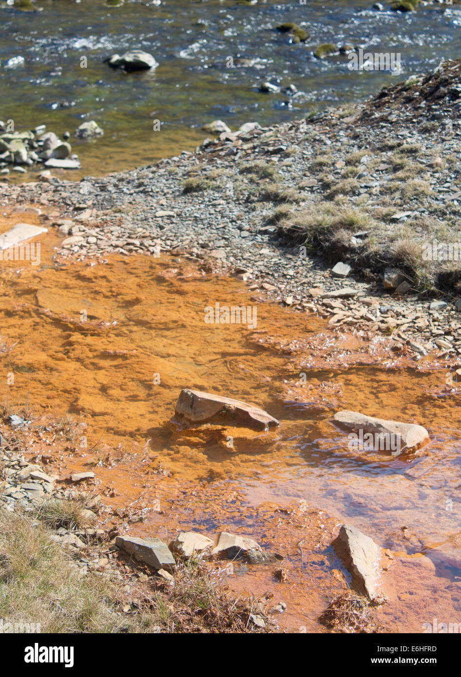 Verunreinigtes Wasser fließt aus Stream von verlassenen Blei-Mine in Fluss mit sauberem Wasser Cwmystwyth Mid Wales UK verschmutzt Stockfoto