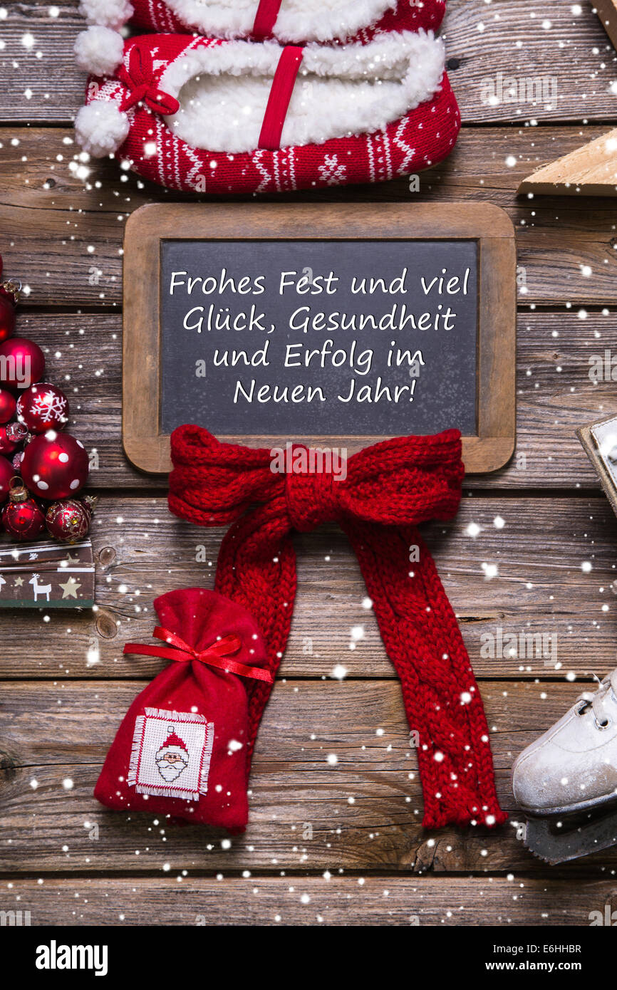 Frohe Weihnachtsgrußkarte in rot und weiß mit Holz und deutscher Text. Stockfoto