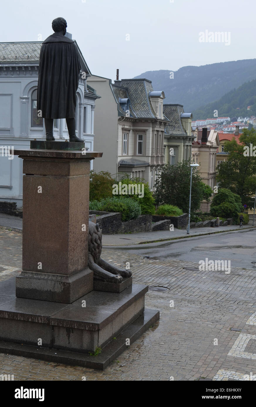 Eine Statue (von Henrick Ibsen oder Edward Grieg?) schaut aus dem Nationaltheater an einem regnerischen Tag in Bergen. Stockfoto