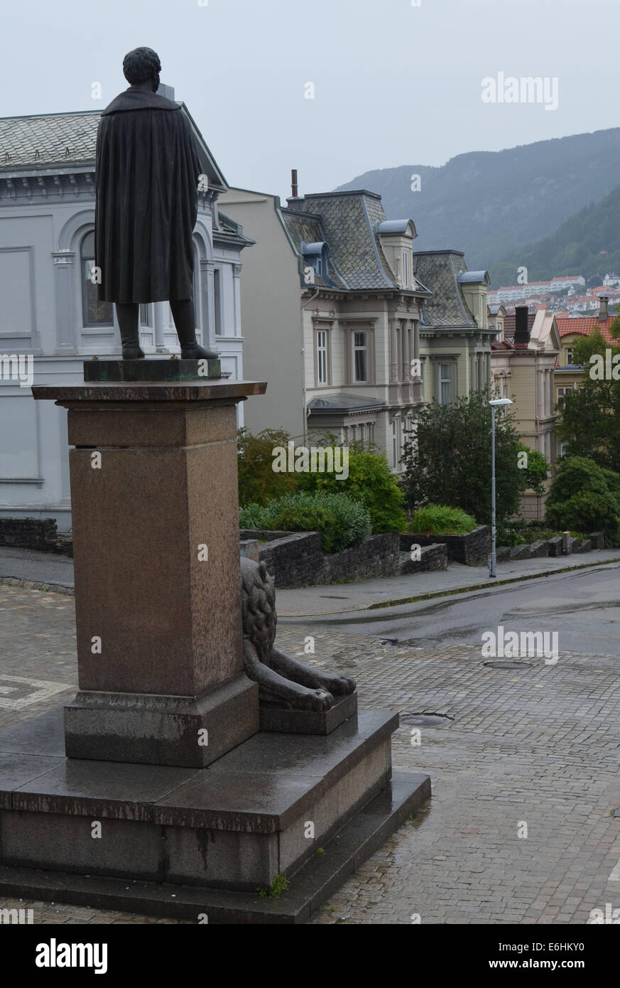 Eine Statue (von Henrik Ibsen oder Edward Grieg?) schaut aus dem Nationaltheater an einem regnerischen Tag in Bergen. Stockfoto