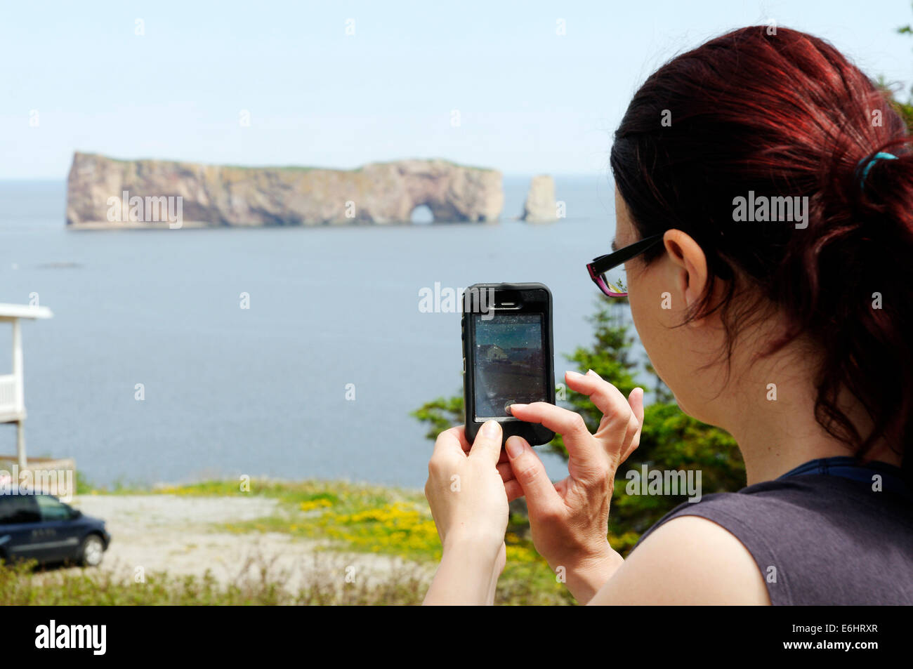 Eine Frau die Bilder von der Rocher Percé in Gaspesie mit ihrem Iphone, Quebec Stockfoto
