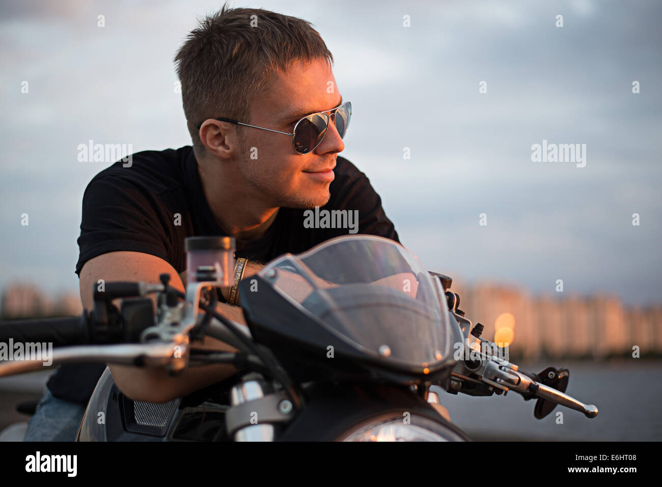 Romantische Porträt schöner Biker Mann mit Sonnenbrille sitzt auf einem Fahrrad Stockfoto