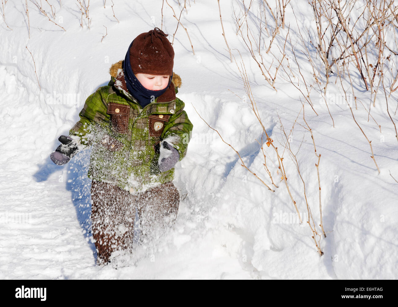 Ein 2 Jahre alter Junge spielt mit Neuschnee in Quebec Kanada Stockfoto