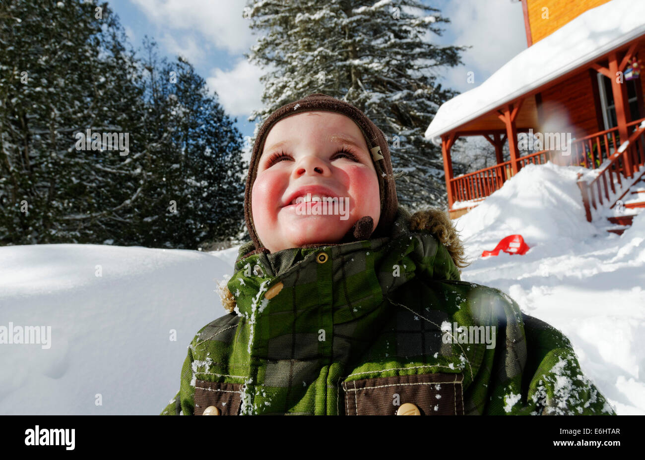Portrait eines 2 Jahre alten Jungen mit Schnee bedeckt im Winter in Québec Stockfoto