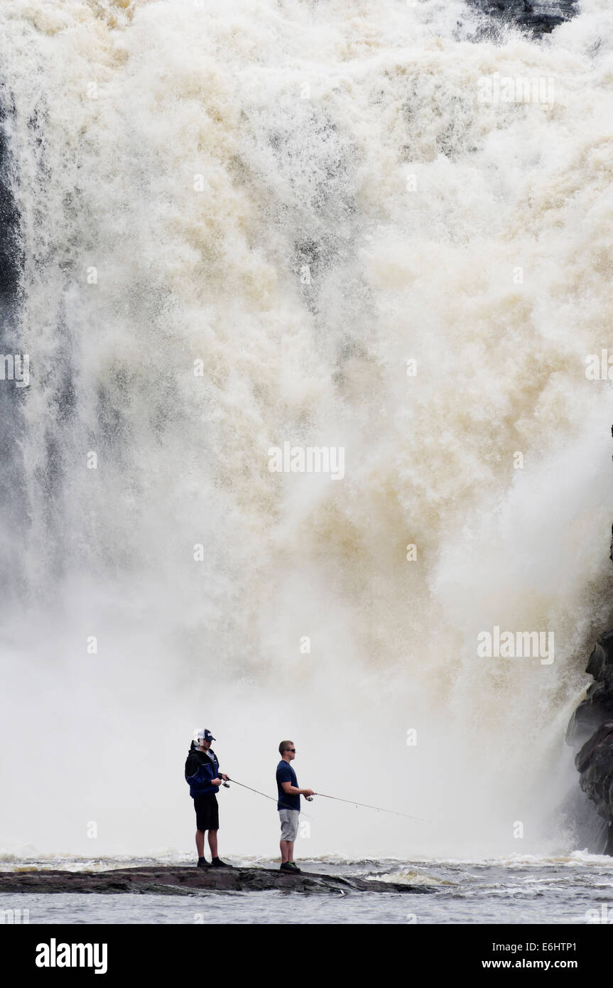 Zwei wilde Fischern, die mit dem Chute De La Chaudiere Wasserfall donnernd hinter ihnen in Quebec Kanada Stockfoto