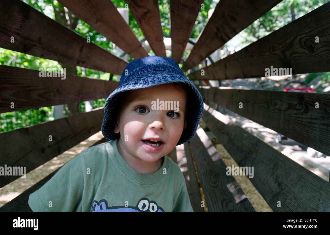 Ein kleiner Junge in einem hölzernen Tunnel auf einem Hindernisparcours Stockfoto