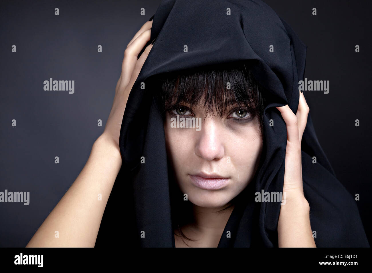 Beängstigend Frau mit einem blassen Gesicht. Mit schwarzem Tuch bedeckt. Stockfoto