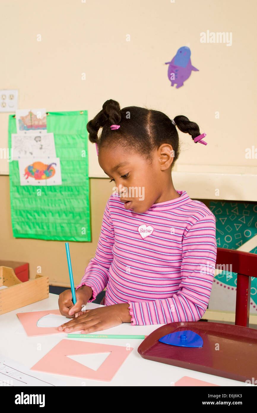 Multi ethnisch vielfältigen schwarzen Mädchen schreibt 4-5 Jahre alten Studenten student Mädchen Kind arbeiten Studium Schule Schreibtisch HERR © Myrleen Pearson Stockfoto
