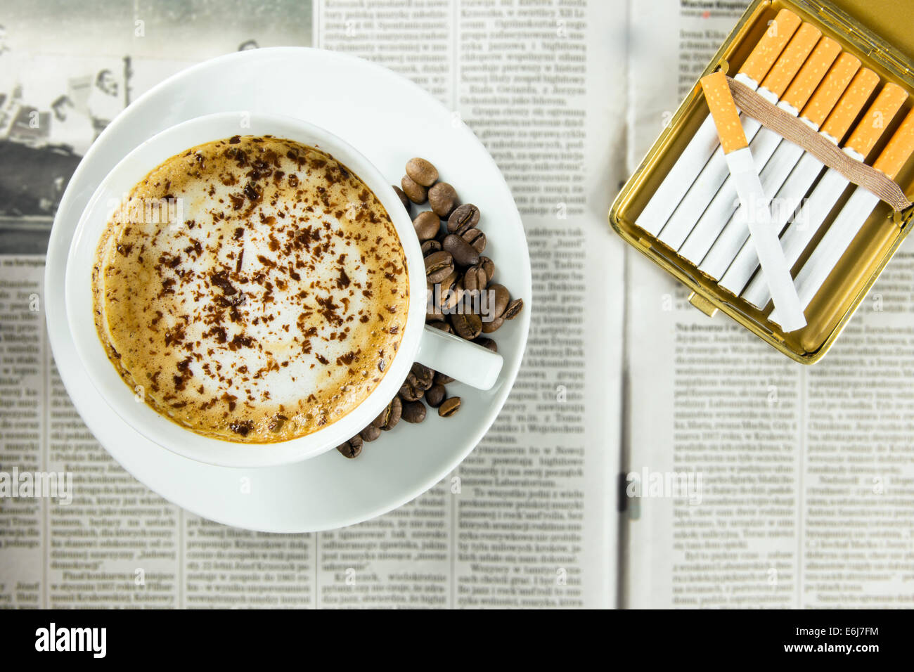 Tasse Kaffee, gerösteten Bohnen und Zigaretten angeordnet auf einer Zeitung Stockfoto