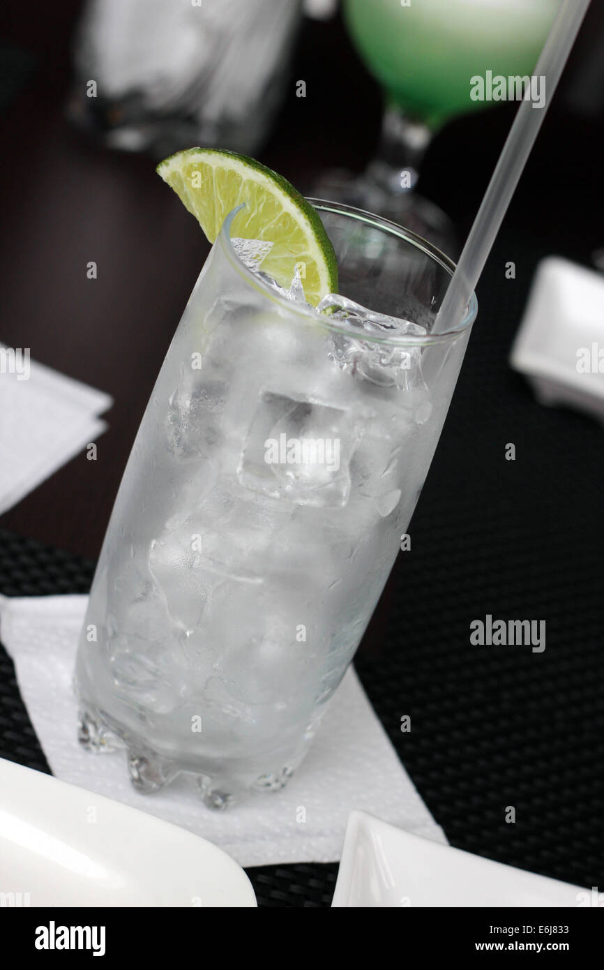 Leeres Glas mit Eis und Zitrone mit einem Getränk servierbereit. Stockfoto
