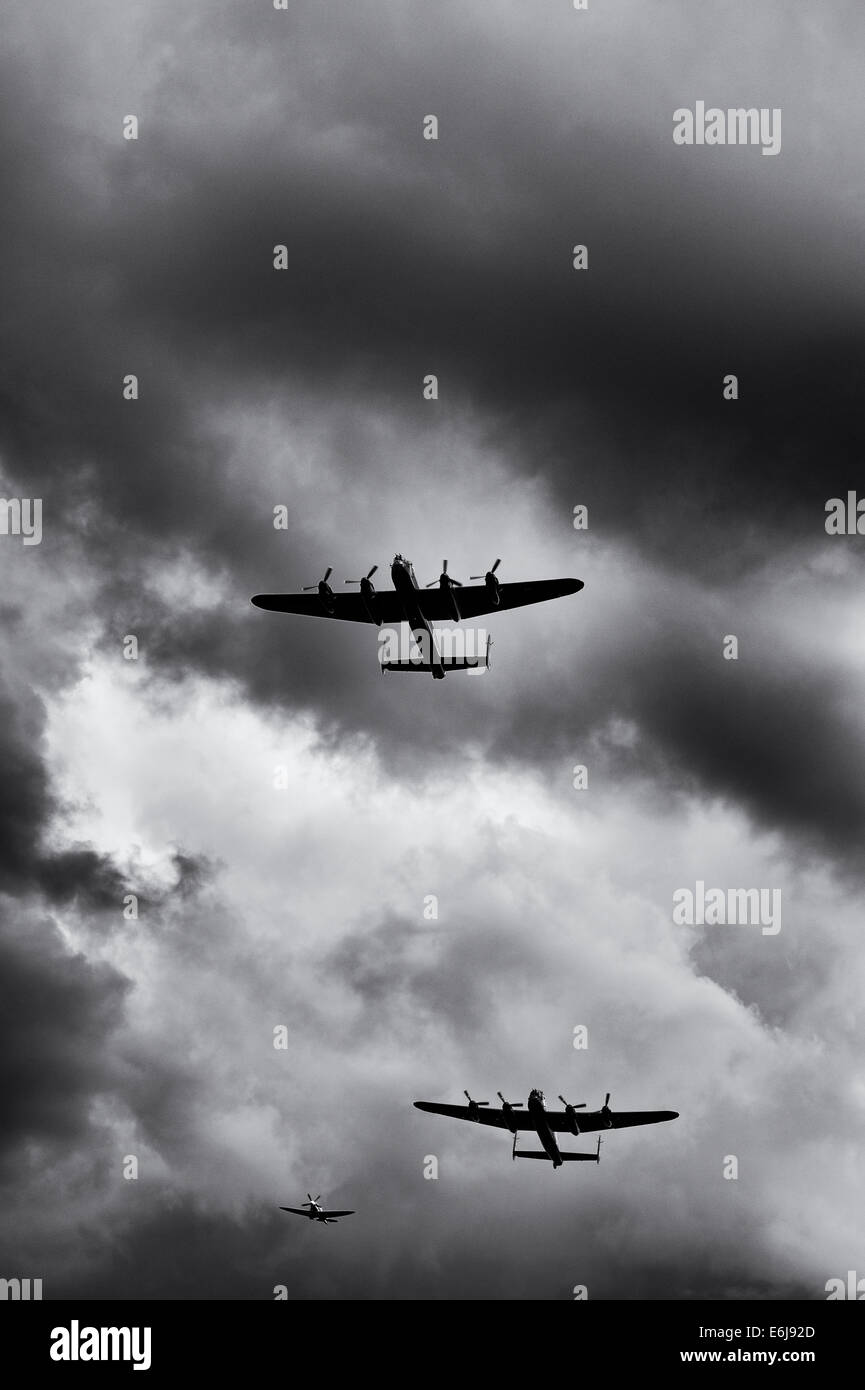 Lancaster-Bomber und Spitfire Flugzeuge fliegen Vergangenheit gegen stürmischen Regenwolken an militärischen Odyssey zeigen, Detling, Kent, England. Stockfoto