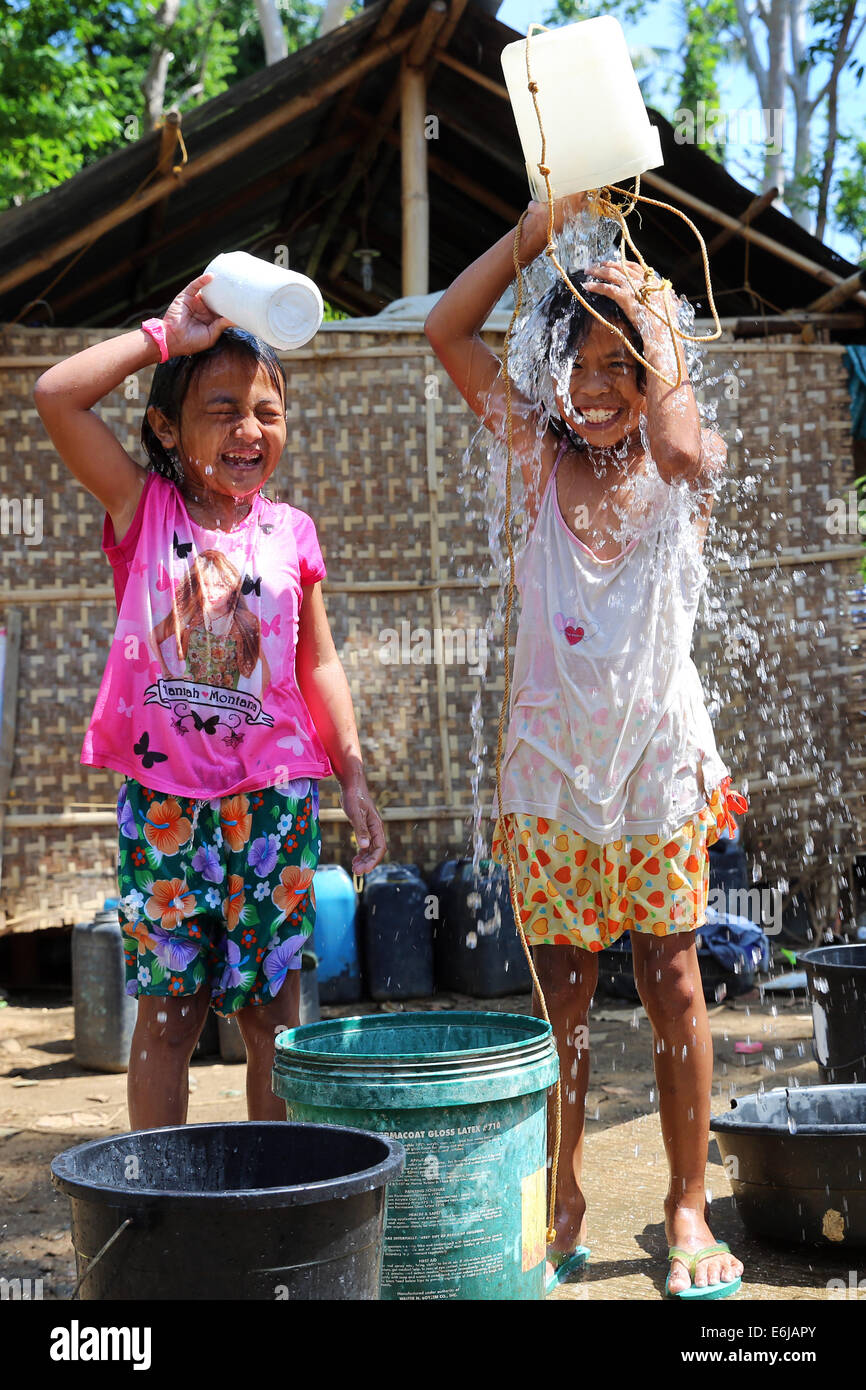 Zwei Kinder gießt Wasser aus einem Eimer auf dem Kopf. Die Philippinen  Stockfotografie - Alamy