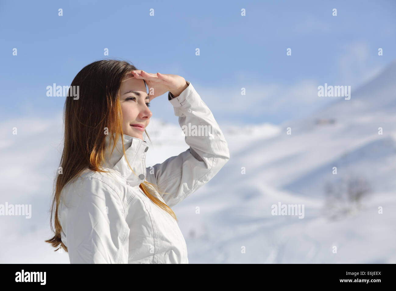 Wanderer-Frau freut sich in den verschneiten Bergen mit ihrer Hand auf Stirn Stockfoto