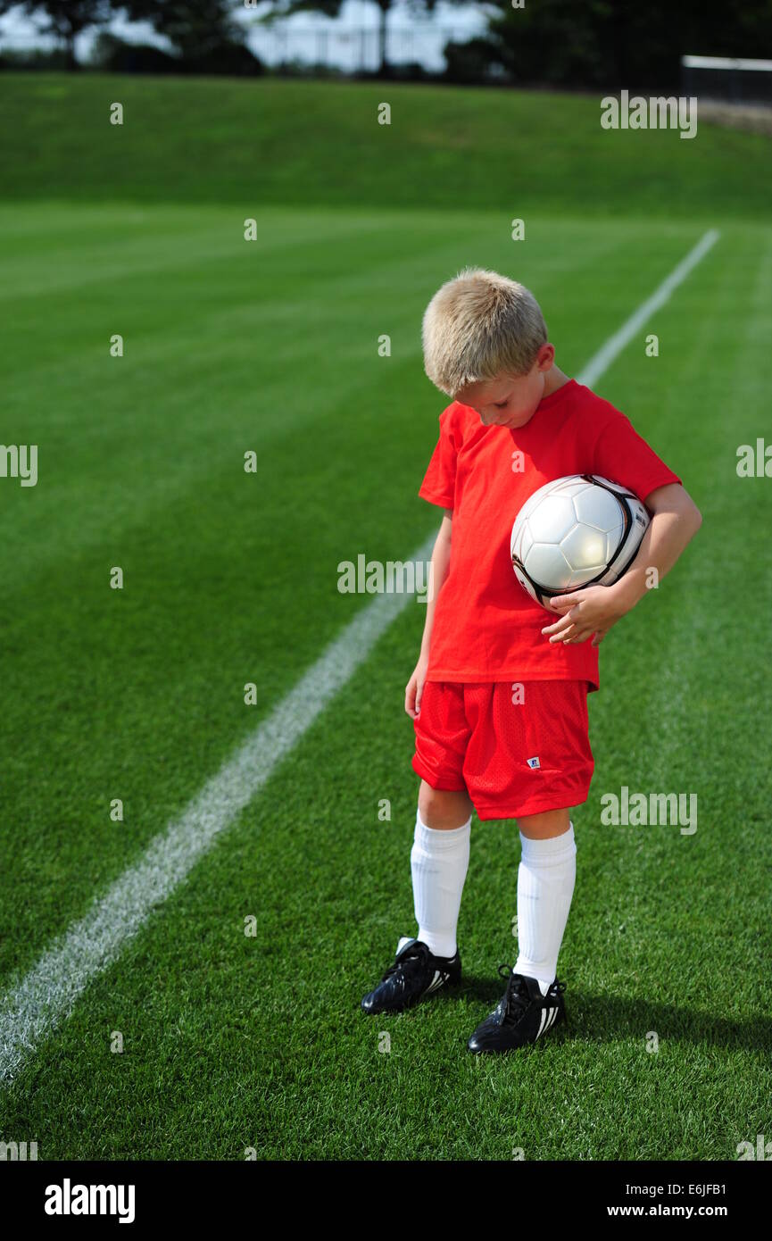 Junge 9 10 11 spielen Futbol Fußball auf grasbewachsenen Pitch-Bereich nicht immer zu spielen Stockfoto