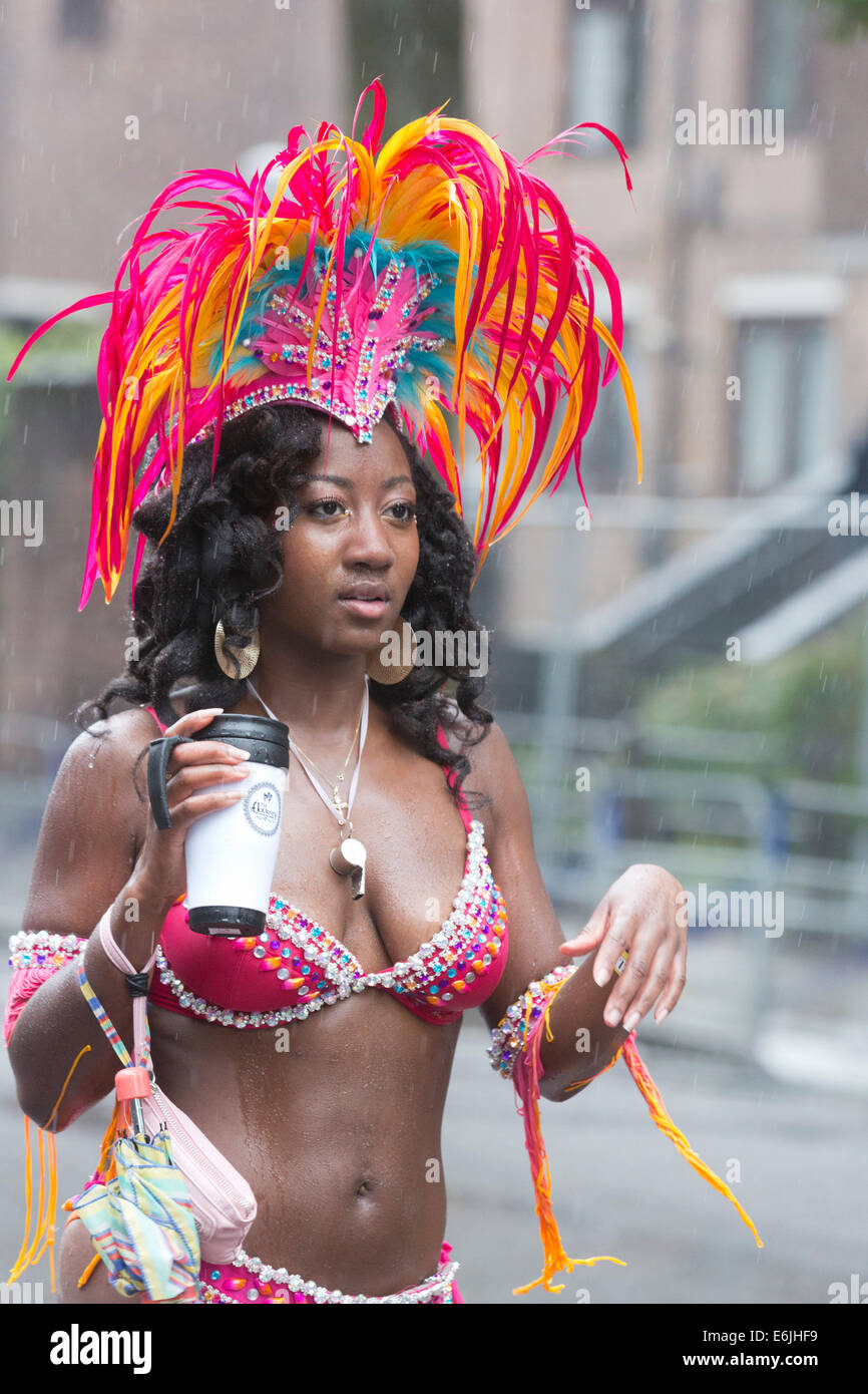 London, UK. 25. August 2014. Besucher und Teilnehmer der Notting Hill Carnival 2014 Bank Holiday Montag Parade nass auf ihrer Haut bekam, aber das Wetter konnte nicht die Nachtschwärmer-Geist - dämpfen, obwohl viele Zuschauer ausblieb. Foto: Nick Savage/Alamy Live-Nachrichten Stockfoto