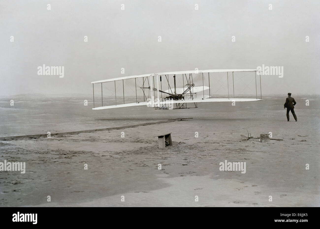 Wilbur Wright Uhren als Bruder Orville Wright Piloten der Wright Flyer während den ersten erfolgreichen nachhaltigen Motorflug 17. Dezember 1903 in Kill Devil Hills, North Carolina. Stockfoto