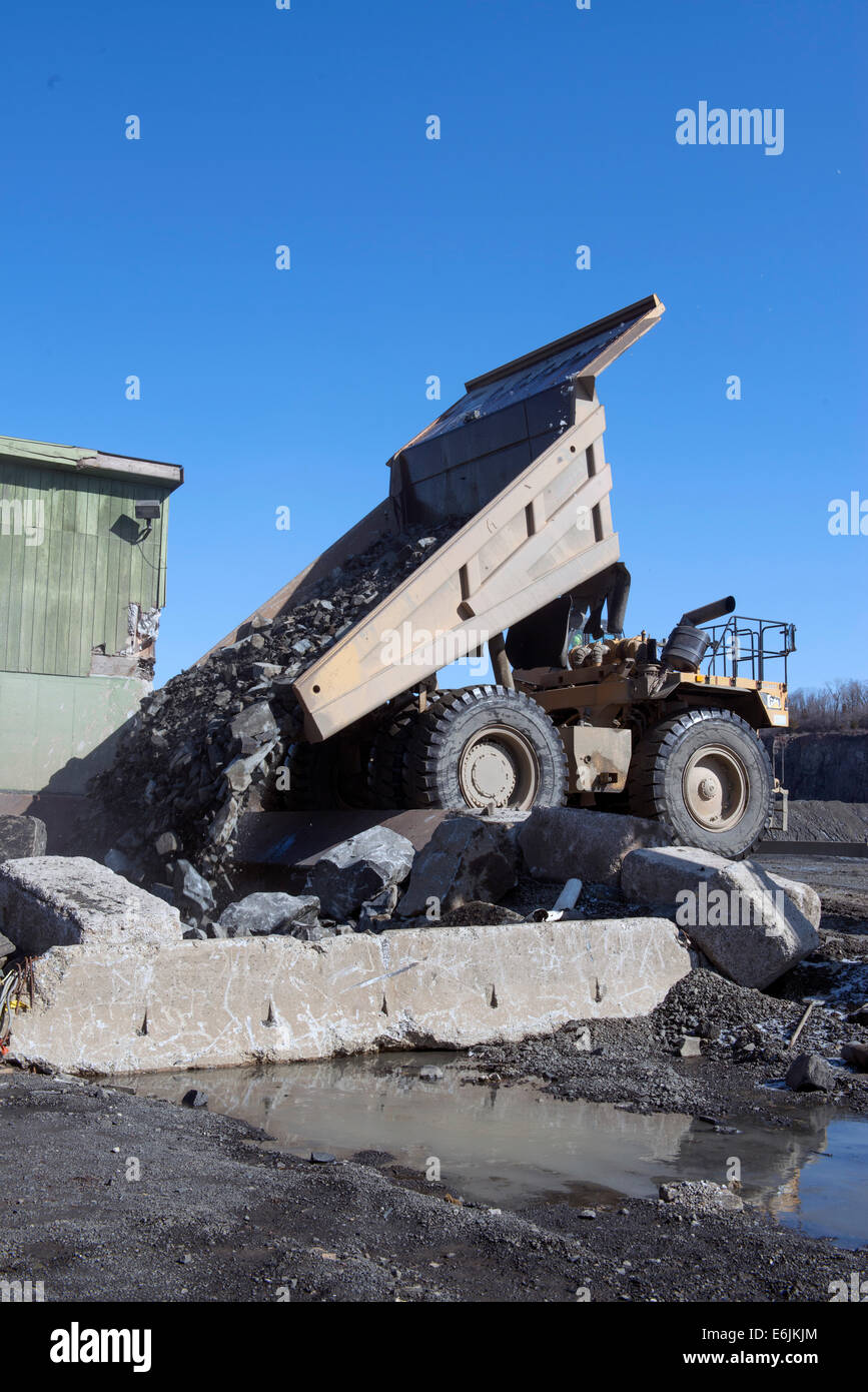 Branford, CT.  100-Tonnen-Caterpillar 7770 D LKW leert Falle Basaltgestein aus Basalt Ridge in Brecher Tilcon Steinbruch abgebaut Stockfoto