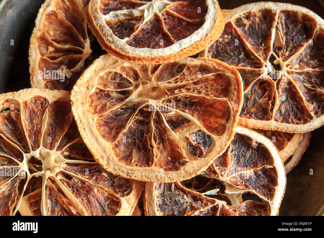 Nahaufnahme von getrockneten Orangenscheiben auf schwarzem Teller Stockfoto