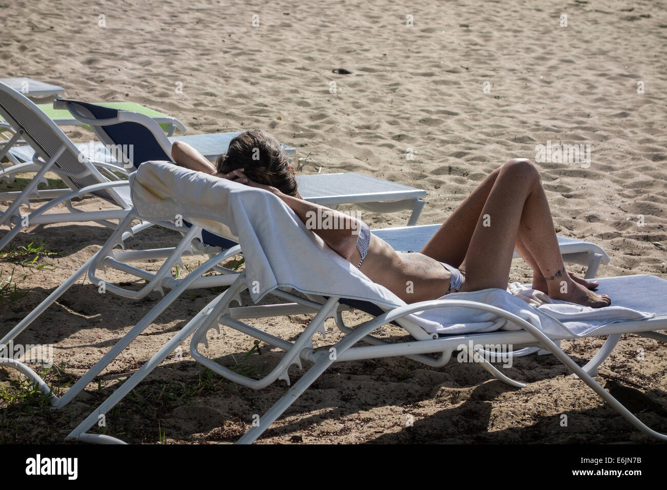 Eine tätowierte kaukasischen Frau im Bikini genießt Entspannung am Strand von St. Croix, Amerikanische Jungferninseln. Stockfoto