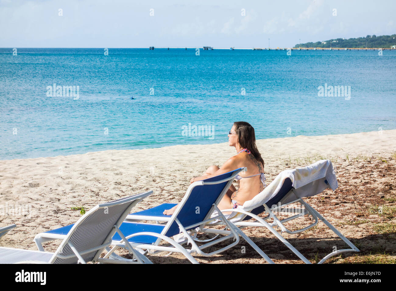 Eine tätowierte kaukasischen Frau im Bikini genießt das Karibische Meer am Strand von St. Croix, Amerikanische Jungferninseln. Stockfoto
