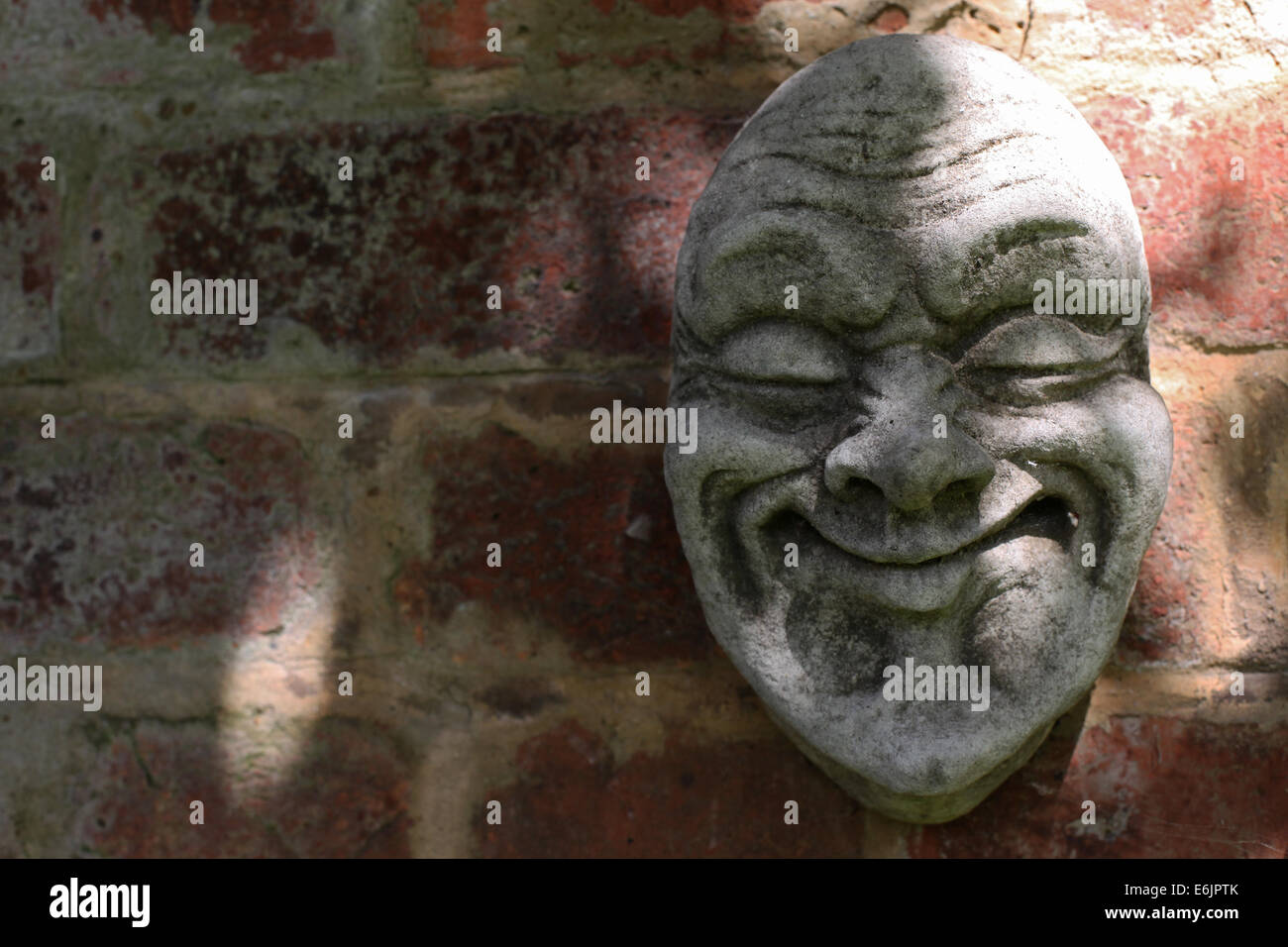 Stone Gesicht an Wand Stockfoto