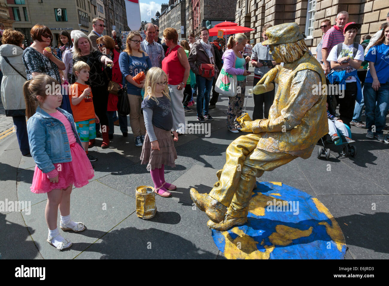 Zwei junge Mädchen starrte auf ein Straßenkünstler wie eine Statue offenbar defying Gravity, Edinburgh Fringe Festival, Edinburgh Stockfoto