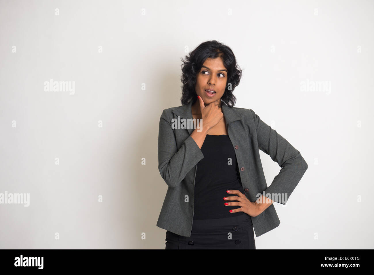 indische Geschäftsfrau mit einfarbigen Hintergrund denken Stockfoto